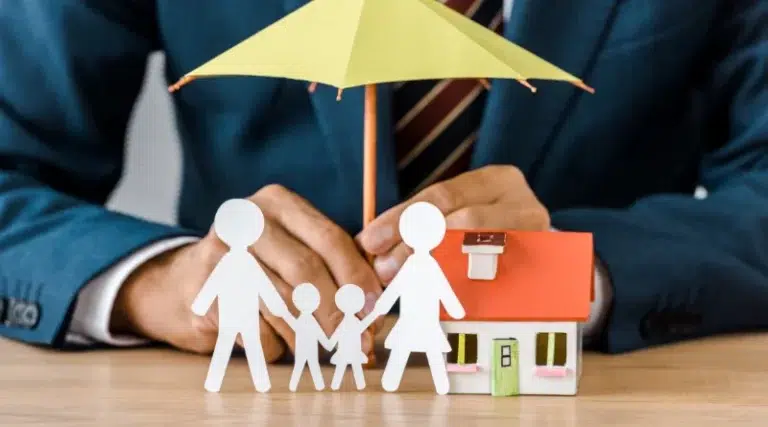 famille en papier en dessous d'un petit parapluie